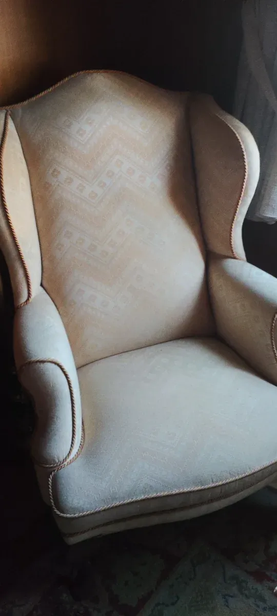 Butaca de madera tapizada.