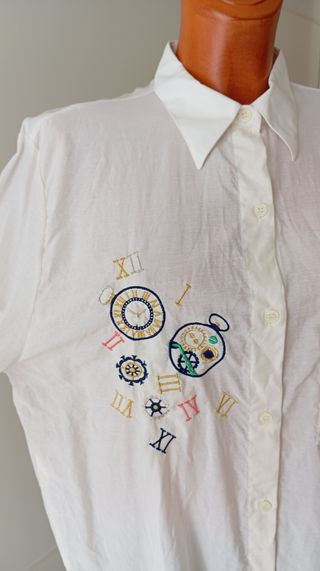 Camisa vintage blanca con estampado de relojes.