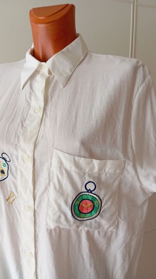 Camisa vintage blanca con estampado de relojes.