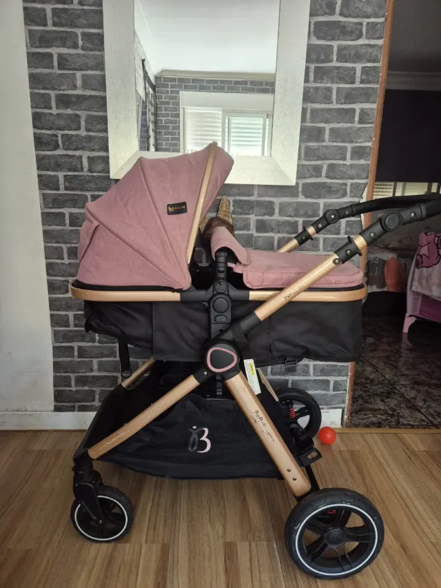 Carrito de bebé rosa y dorado