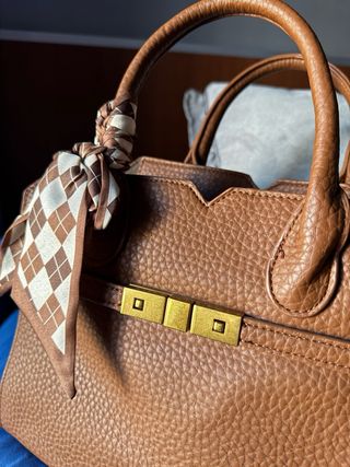 Bolso de piel marrón con pañuelo.