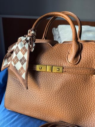 Bolso de piel marrón con pañuelo.