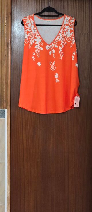 Blusa sin mangas naranja con detalle floral.