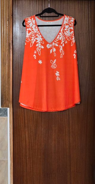 Blusa sin mangas naranja con detalle floral.