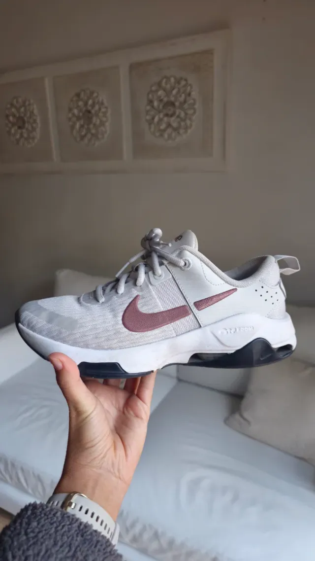 Zapatilla Nike gris y logotipo marrón.