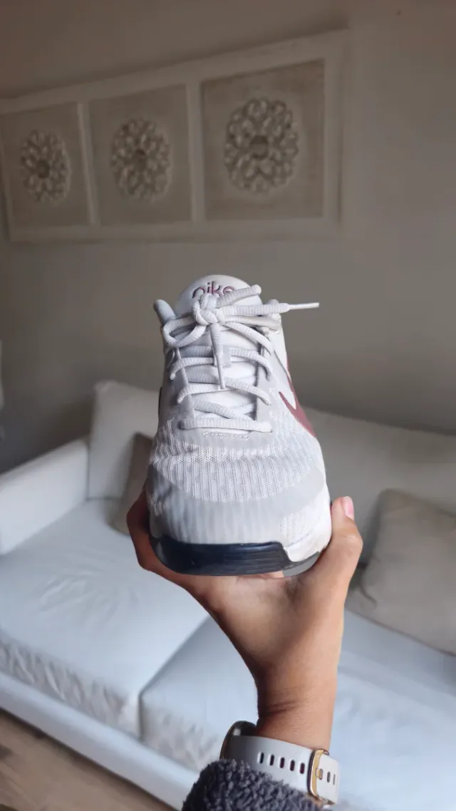 Zapatilla Nike gris y logotipo marrón.