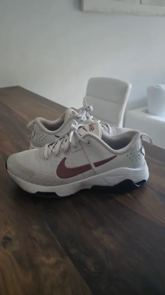 Zapatilla Nike gris y logotipo marrón.