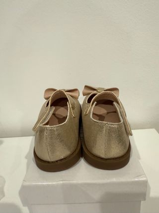 Zapatos dorados niña con lazo
Talla 24