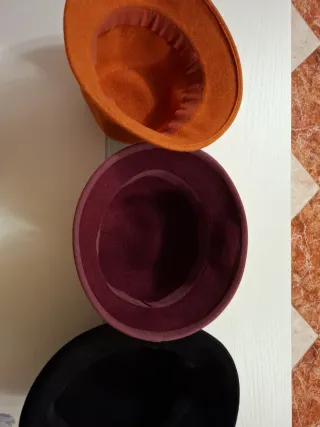 Sombreros de lana naranjas y morados