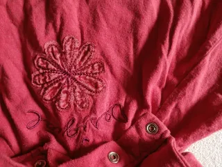 Ropa infantil con flor bordada desigual