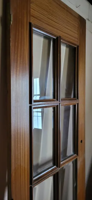 Puertas de madera maciza, una con cristales.