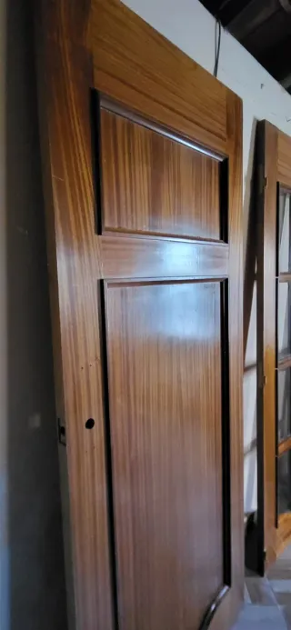 Puertas de madera maciza, una con cristales.