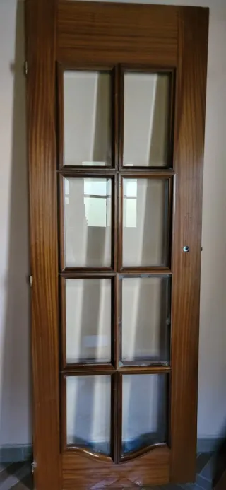 Puertas de madera maciza, una con cristales.