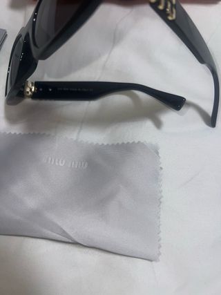 Gafas de sol Miu Miu negras y doradas