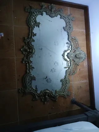 Espejo de bronce con marco ornamentado