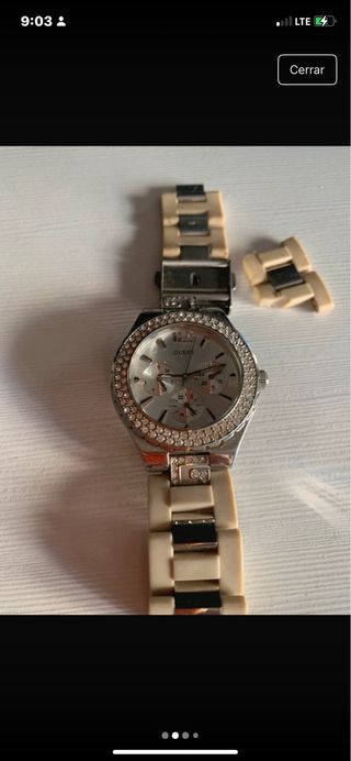 Reloj Guess con brillantes plateado y beige.