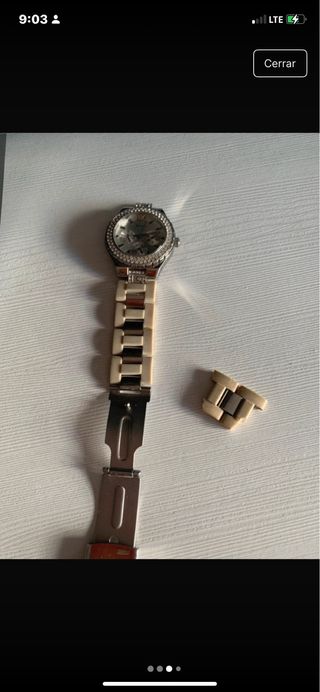 Reloj Guess con brillantes plateado y beige.