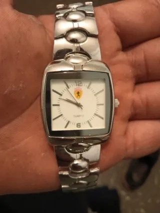 Reloj de pulsera plateado con esfera blanca