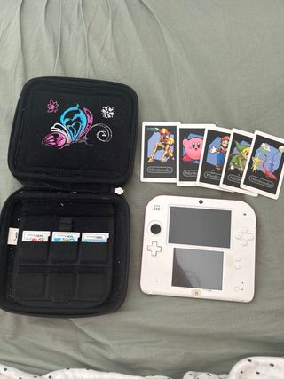 Nintendo 2DS rosso e bianco con copertina e giochi