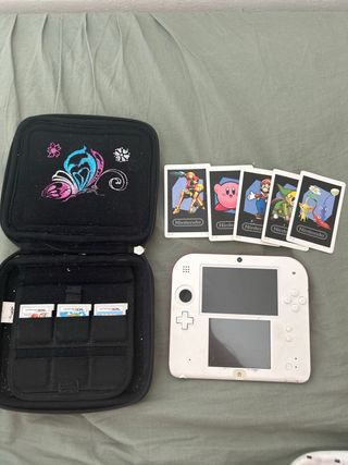 Nintendo 2DS rosso e bianco con copertina e giochi
