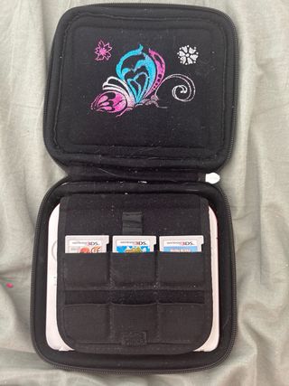 Nintendo 2DS rosso e bianco con copertina e giochi
