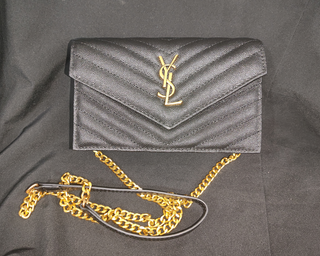 Bolso YSL sobre negro con cadena dorada