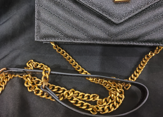 Bolso YSL sobre negro con cadena dorada
