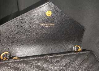 Bolso YSL sobre negro con cadena dorada