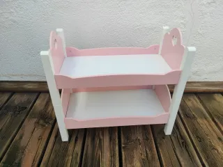 Cuna gemelar de juguete rosa y blanca.