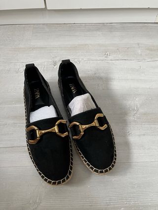 Zapatos planos negros con detalle dorado 