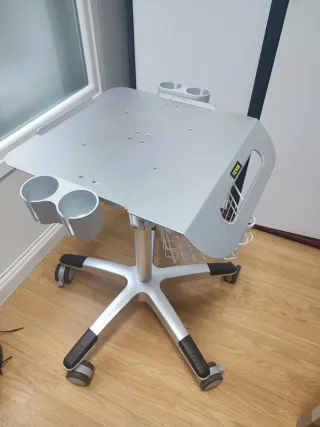 Mesa médica con ruedas, cesta y porta embases. 