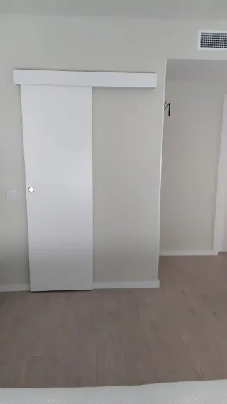 Puerta corredera lacada en blanco.