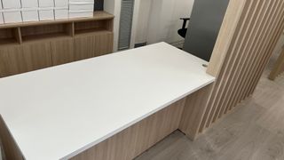 Mesa de oficina blanca con celosía a mediodía.