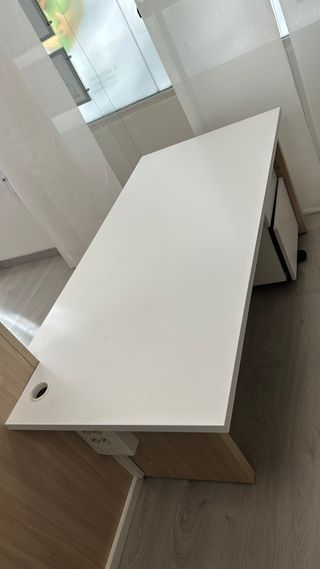Mesa de oficina blanca con celosía a mediodía.
