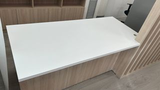 Mesa de oficina blanca con celosía a mediodía.