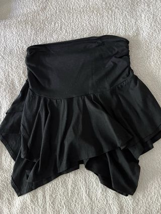 Falda negra con corte de puntas, cortita.