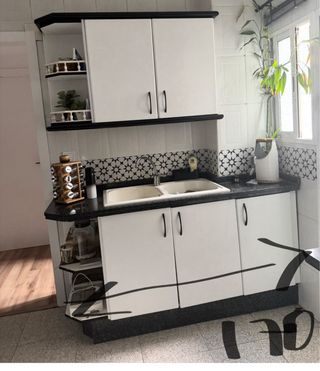 Cocina blanca y negra con encimera de granito.