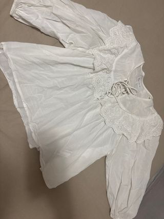 Blusa blanca con volantes y lazada