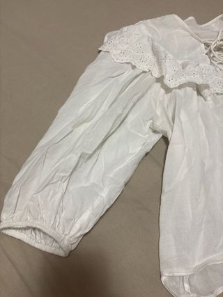 Blusa blanca con volantes y lazada