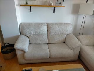 Sofá de 2 plazas blanco con pinturas marrones.
