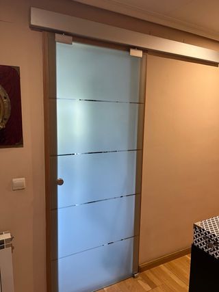 Puerta corredera de cristal esmerilado.