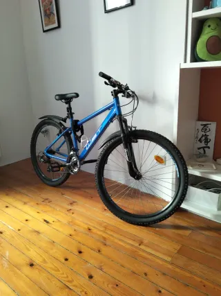 Bicicleta azul de montaña con muy poco uso