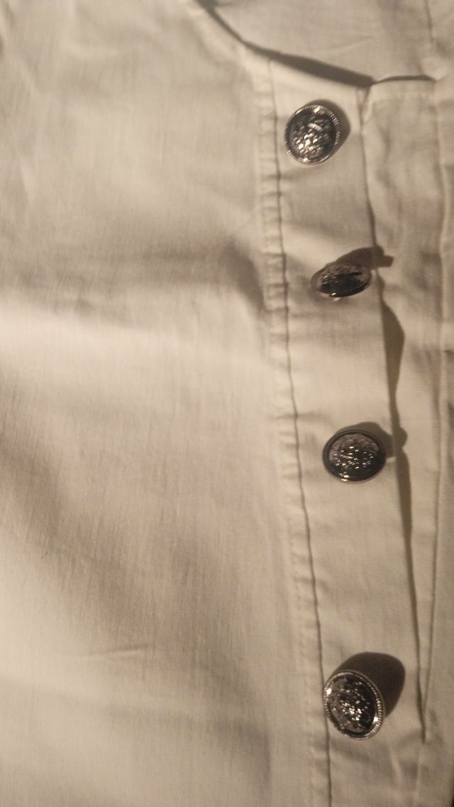 Calça branca com botões prateados