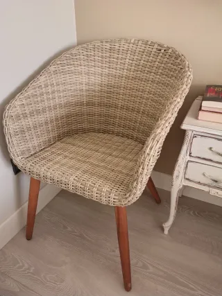 Sillón de mimbre beige con patas de madera