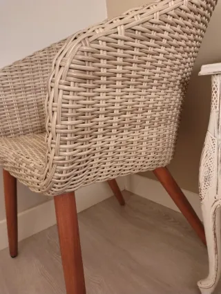 Sillón de mimbre beige con patas de madera