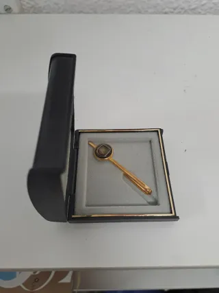 Alfiler de corbata dorado con piedra