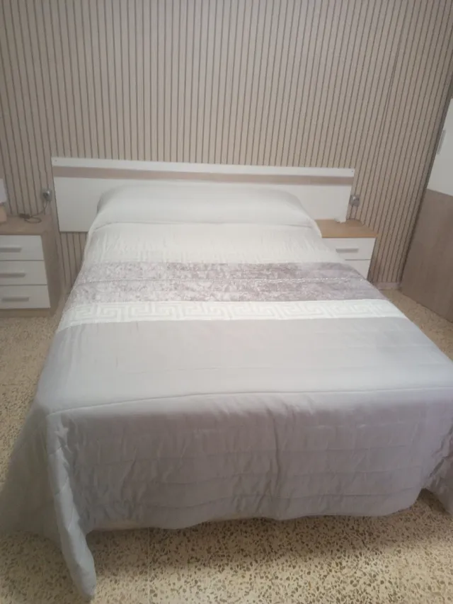 Colcha Cama Gris y Blanca y lleva una tira de bril