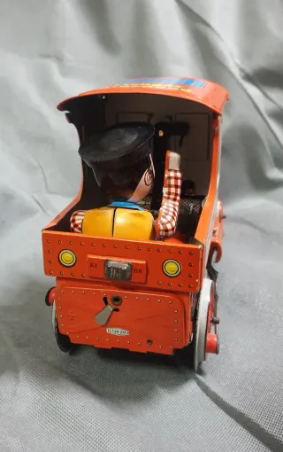 Tren de hojalata antiguo con figura.
