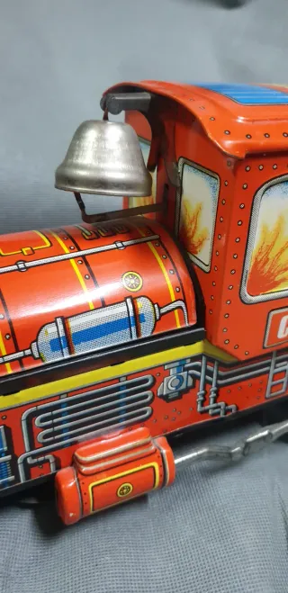 Tren de hojalata antiguo con figura.