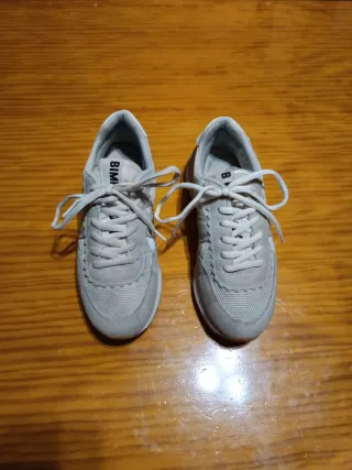 Zapatillas deportivas gris con blanco.